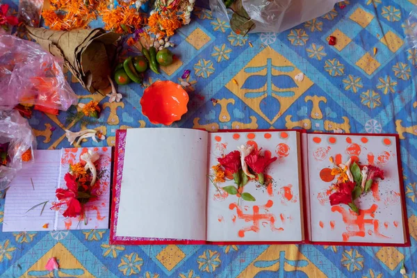 New accounts books opened to start writing in new year, are being worshipped on auspicious day of Bengali new year, called nabobarsho. Holy hibiscus flower, swastika sign on the pages as per ritual.