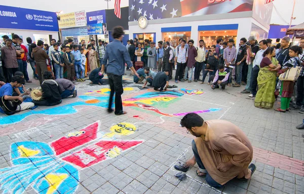 KOLKATA, INDIA - FEBRUARY 5TH : Young artists painting floor at Kolkata book fair, on February 5th, 2015 in Kolkata. It is world's largest, most attended and famous non-trade book fair.