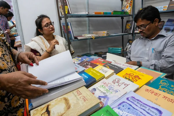 KOLKATA, INDIA - 9 Şubat 2018: Kolkata kitap fuarındaki güzel Bengalli kadın müşterilerin sorularını cevaplayan kitap satıcısı. Dünya 'nın en büyük, en katılımcı ve en ünlü ticaret dışı kitap fuarıdır..