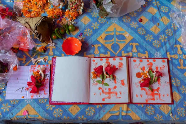 New accounts books opened to start writing in new year, are being worshipped on auspicious day of Bengali new year, called nabobarsho. Holy hibiscus flower, swastika sign on the pages as per ritual.