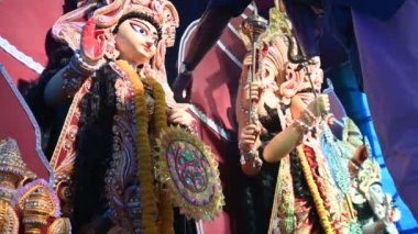 Howrah, Batı Bengal, Hindistan - 5 Ekim 2019: Hindu Bengalli rahip, tanrıça Laxmi 'ye tapınmadan önce onun heykelinin üzerine elbise koyuyor. Durga Puja Festivali, tüm dünyada kutlandı..