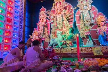 Howrah, Batı Bengal, Hindistan - 5 Ekim 2019: Durga Puja festivalinde Durga Puja pandalı içinde tanrıça Durga 'ya taptıkları için Durga puja' da Sanskritçe şarkılar söyleyen Hindu Bengali şarkıları.