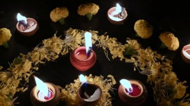 Rangoli çiçekleri, mumlar ya da etrafına diwali ışıkları konmuş. Karanlık arkaplan görüntüsü.
