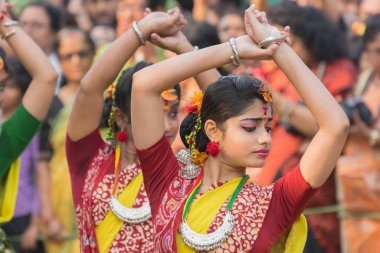 KOLKATA, INDIA - 12 Mart 2017: Sarı ve kırmızı sari (geleneksel Hint elbisesi) giymiş kız dansçıların dans pozları, Dol / Holi.