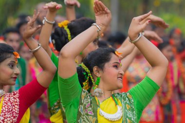 KOLKATA, INDIA - 12 Mart 2017: Sarı ve kırmızı sari giymiş genç kız dansçılar (geleneksel Hint elbisesi) Bahar festivalinde dans ediyorlar, ie, Dol (Bengalce) veya Holi (Hintçe)).