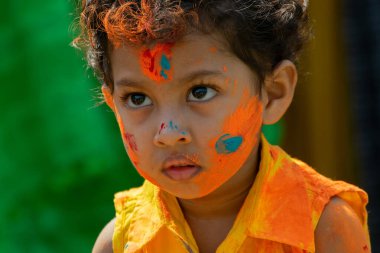 Kolkata, Hindistan - 21 Mart 2019: Yüzünde bahar festivali renginde genç bir çocuğun portresi, Holi festivalinde Dol (Bengalce) veya Holi (Hintçe) olarak bilinen ciddi düşünme ifadesi (Hintçe)).