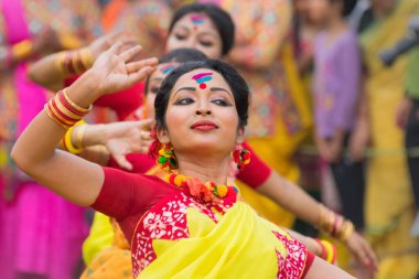 KOLKATA, INDIA - 12 Mart 2017: Sarı ve kırmızı sari (geleneksel Hint elbisesi) giymiş kız dansçıların dans pozları, Dol / Holi.