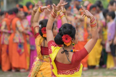 KOLKATA, INDIA - 12 Mart 2017: Sarı ve kırmızı sari (geleneksel Hint elbisesi) giymiş kız dansçıların dans pozları, Dol / Holi.