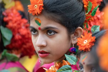 KOLKATA, INDIA - 1 Mart 2018: Geleneksel Hint sarisi ve Palash çiçekleri giymiş kız dansçının ifadesi - Butea monosperma, makyaj, Dol veya Holi 'de dans - Hindistan' daki bahar festivali.