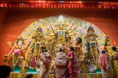 KOLKATA, INDIA - 18 Ekim 2015: Puja pandalında Durga idolüne tapan evli Bengalli kadınlar, Kolkata, Batı Bengal, Hindistan 'da renkli ışıkta vuruldular. Durga Puja, Hinduizm 'in en büyük dini festivali..
