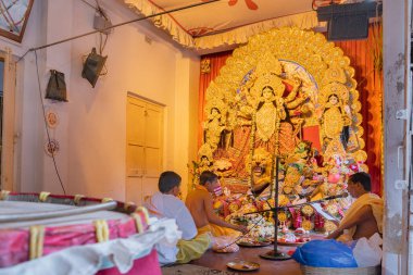 KOLKATA, INDIA - SEPTEMBER 28, 2017: Hindu rahipler bir Bengali evinde tanrıça Durga 'ya tapıyorlar. Durga Puja, Hinduizm 'in en büyük dini festivali..