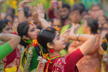 KOLKATA, INDIA - 12 Mart 2017: Sarı ve kırmızı sari giymiş genç kız dansçılar (geleneksel Hint elbisesi) Bahar festivalinde dans ediyorlar, ie, Dol (Bengalce) veya Holi (Hintçe)).