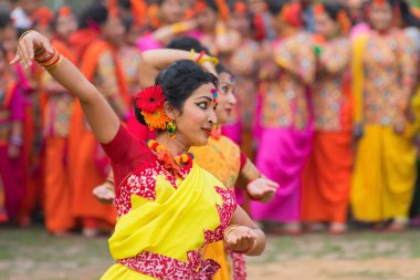 KOLKATA, INDIA - 12 Mart 2017: Sarı ve kırmızı sari (geleneksel Hint elbisesi) giymiş kız dansçıların dans pozları, Dol / Holi.