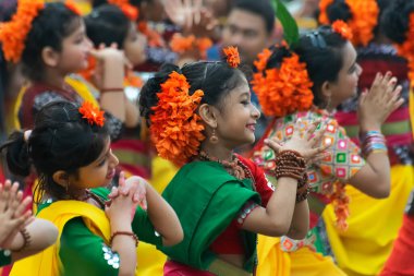 KOLKATA, INDIA - 1 Mart 2018: Sarı ve yeşil sari giymiş genç kız dansçılar - Palash çiçekli geleneksel Hint elbisesi, Butea monosperma, Holi Bahar Festivali 'nde dans .