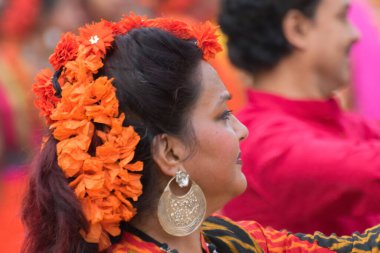 KOLKATA, INDIA - 12 Mart 2017: Turuncu Palaş Çiçeği (Butea monosperma), bahar çiçeği, makyajlı bir kız dansçının başında, Bahar Festivali 'nde dans, Dol / Holi festivali.