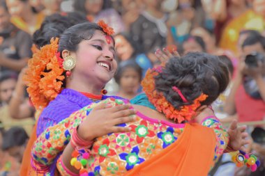 KOLKATA, INDIA - 12 Mart 2017: Sari (geleneksel Hint elbisesi) giymiş kız dansçılar ve Palash çiçekleri (Butea monosperma) makyaj, Dol (Bengalce) veya Holi (Hintçe) festivalinde dans.
