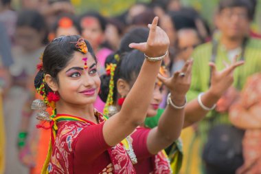 KOLKATA, INDIA - 12 Mart 2017: Sarı ve kırmızı sari (geleneksel Hint elbisesi) giymiş kız dansçıların dans pozları, Dol / Holi.