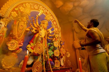 Kolkata, Hindistan - 16 Ekim 2018: Tanrıça Durga 'ya tapan genç Hindu rahip kutsal dumanın altında, Durga Puja festivali ritüeli. - Renkli ışığın altında gece çekilmiş. Hindu Festivali.