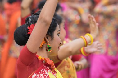 KOLKATA, INDIA - 12 Mart 2017: Sarı ve kırmızı sari (geleneksel Hint elbisesi) giymiş kız dansçıların dans pozları, Dol / Holi.