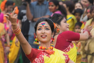 KOLKATA, INDIA - 12 Mart 2017: Sarı ve kırmızı sari giymiş genç kız dansçılar (geleneksel Hint elbisesi) Bahar festivalinde dans ediyorlar, ie, Dol (Bengalce) veya Holi (Hintçe)).