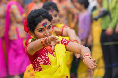 KOLKATA, INDIA - 12 Mart 2017: Sarı ve kırmızı sari (geleneksel Hint elbisesi) giymiş kız dansçıların dans pozları, Dol / Holi.