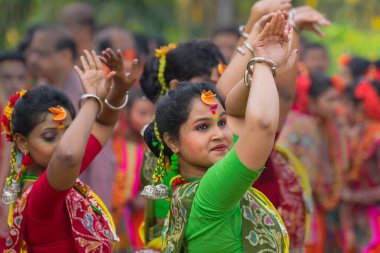 KOLKATA, INDIA - 12 Mart 2017: Sarı ve kırmızı sari giymiş genç kız dansçılar (geleneksel Hint elbisesi) Bahar festivalinde dans ediyorlar, ie, Dol (Bengalce) veya Holi (Hintçe)).