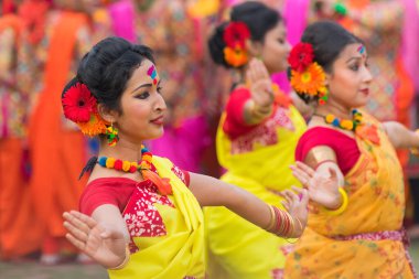 KOLKATA, INDIA - 12 Mart 2017: Sarı ve kırmızı sari giymiş genç kız dansçılar (geleneksel Hint elbisesi) Bahar festivalinde dans ediyorlar, ie, Dol (Bengalce) veya Holi (Hintçe)).