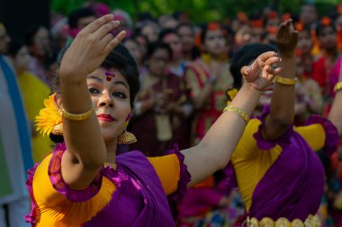 Kolkata, Hindistan - 21 Mart 2019: Sari giymiş kız dansçılar, Palash çiçekli geleneksel Hint elbisesi, Butea monosperma, makyaj, Holi festivalinde dans. Hindistan 'a Bahar geliyor..