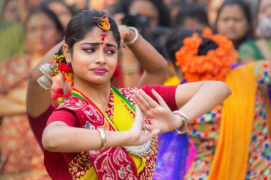 KOLKATA, INDIA - 12 Mart 2017: Sarı ve kırmızı sari giymiş genç kız dansçılar (geleneksel Hint elbisesi) Bahar festivalinde dans ediyorlar, ie, Dol (Bengalce) veya Holi (Hintçe)).