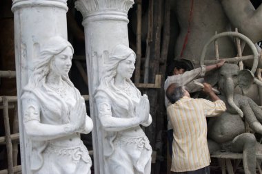 KOLKATA, Batı BENGAL, INDIA - 13 Eylül 2015: Tanınmayan sanatçılar Lord Ganesha 'nın kil putunu hazırlıyorlar, iki Apsaras (ilahi güzellikler) Kumartuli, Kolkata' da 