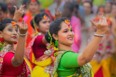 KOLKATA, INDIA - 12 Mart 2017: Sarı ve kırmızı sari giymiş genç kız dansçılar (geleneksel Hint elbisesi) Bahar festivalinde dans ediyorlar, ie, Dol (Bengalce) veya Holi (Hintçe)).