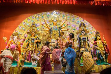 KOLKATA, INDIA - 18 Ekim 2015: Puja pandalında Durga idolüne tapan evli Bengalli kadınlar, Kolkata, Batı Bengal, Hindistan 'da renkli ışıkta vuruldular. Durga Puja, Hinduizm 'in en büyük dini festivali..