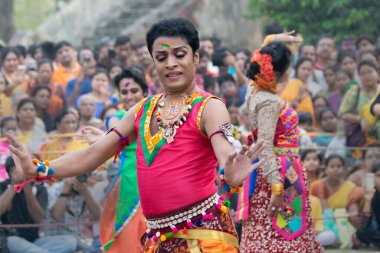 KOLKATA, INDIA - 1 Mart 2018: Bengali erkek dansçısının dans pozu, parlak kırmızı renkler ve süsler, geleneksel Hint elbisesi, bahar festivalinde dans - Dol veya Holi.