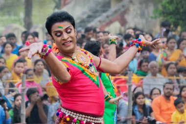 KOLKATA, INDIA - 1 Mart 2018: Bengali erkek dansçısının dans pozu, parlak kırmızı renkler ve süsler, geleneksel Hint elbisesi, bahar festivalinde dans - Dol veya Holi.