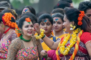 KOLKATA, INDIA - 1 Mart 2018: Sari giymiş kız dansçıların neşeli ifadesi - geleneksel Hint elbisesi ve Palash çiçekleri - Butea monosperma, Dol or Holi - Hindistan 'daki bahar festivali.