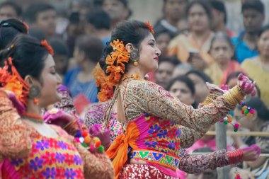 KOLKATA, INDIA - 1 Mart 2018: Açık kırmızı sari giymiş kız dansçıların dans pozları - geleneksel Bengali Hint elbisesi, bahar festivalinde dans. Hindistan 'da Dol veya Holi kutlaması.