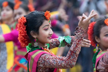 KOLKATA, INDIA - 1 Mart 2018: Açık kırmızı sari giymiş kız dansçıların dans pozları - geleneksel Bengali Hint elbisesi, bahar festivalinde dans. Hindistan 'da Dol veya Holi kutlaması.