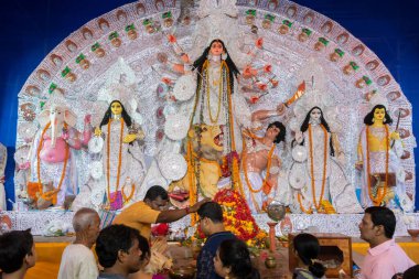 Kolkata, Hindistan - 18 Ekim 2018: Hindu rahip Durga Puja pandalında erkek müridi kutsadı, gece renkli ışıkta vuruldu. Hinduizm 'in en büyük festivali..