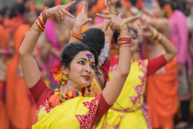 KOLKATA, INDIA - 12 Mart 2017: Sarı ve kırmızı sari giymiş genç kız dansçılar (geleneksel Hint elbisesi) Bahar festivalinde dans ediyorlar, ie, Dol (Bengalce) veya Holi (Hintçe)).