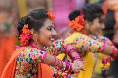KOLKATA, INDIA - 12 Mart 2017: Sari (geleneksel Hint elbisesi) giymiş kız dansçılar ve Palash çiçekleri (Butea monosperma) makyaj, Dol (Bengalce) veya Holi (Hintçe) festivalinde dans.