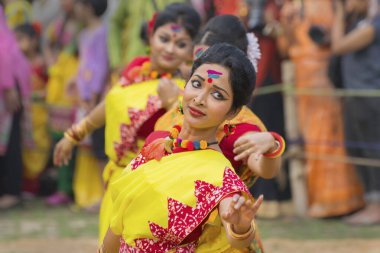 KOLKATA, INDIA - 12 Mart 2017: Sarı ve kırmızı sari giymiş genç kız dansçılar (geleneksel Hint elbisesi) Bahar festivalinde dans ediyorlar, ie, Dol (Bengalce) veya Holi (Hintçe)).