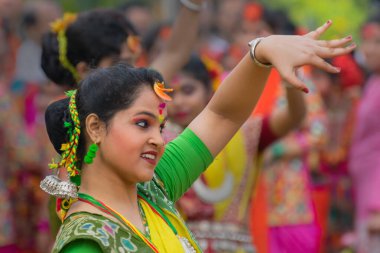 KOLKATA, INDIA - 12 Mart 2017: Sarı ve kırmızı sari (geleneksel Hint elbisesi) ve dol / holi festivalinde dans eden kız dansçının dans pozu.