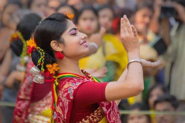 KOLKATA, INDIA - 12 Mart 2017: Sarı ve kırmızı sari giymiş genç kız dansçılar (geleneksel Hint elbisesi) Bahar festivalinde dans ediyorlar, ie, Dol (Bengalce) veya Holi (Hintçe)).