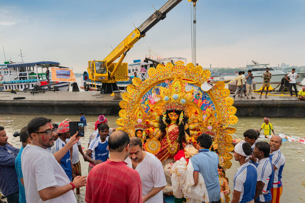 KOLKATA, WEST BENGAL, INDIA - 30 SEPTEMBER 2017: Idol of Goddess Durga is being immersed in Holy river Ganges, called "bisorjon". Event is celebrated by Hindus as "vijaya dashami", Durga Puja festival in Bengal.