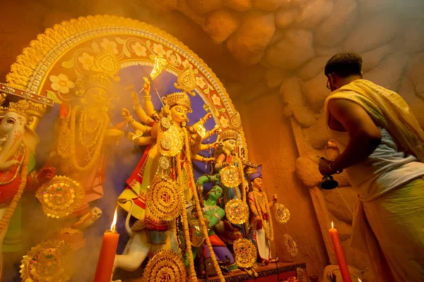 加尔各答 Kolkata India 2018年10月16日 年轻的印度教祭司在神圣的烟幕下 用孔雀壳崇拜女神杜尔加 杜尔加普伽节仪式 夜间在彩灯下拍摄印度教节 — 图库照片