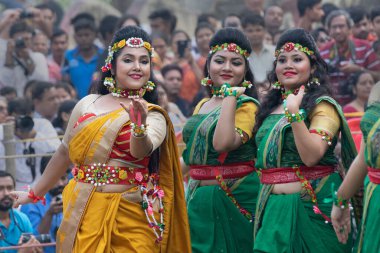 KOLKATA, INDIA - 1 Mart 2018: Sari giymiş uzun saçlı kız dansçıların dans pozları - geleneksel Bengali Hint elbisesi, bahar festivalinde dans. Hindistan 'da Dol veya Holi kutlaması.