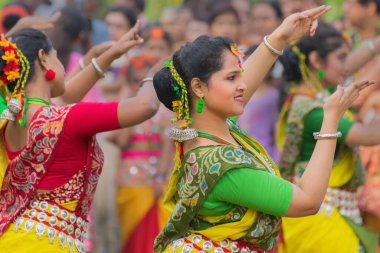 KOLKATA, INDIA - 12 Mart 2017: Sarı ve kırmızı sari giymiş genç kız dansçılar (geleneksel Hint elbisesi) Bahar festivalinde dans ediyorlar, ie, Dol (Bengalce) veya Holi (Hintçe)).