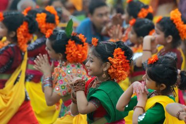 KOLKATA, INDIA - 1 Mart 2018: Sarı ve yeşil sari giymiş genç kız dansçılar - Palash çiçekli geleneksel Hint elbisesi, Butea monosperma, Holi Bahar Festivali 'nde dans .