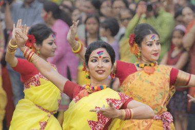 KOLKATA, INDIA - 12 Mart 2017: Sarı ve kırmızı sari giymiş genç kız dansçılar (geleneksel Hint elbisesi) Bahar festivalinde dans ediyorlar, ie, Dol (Bengalce) veya Holi (Hintçe)).
