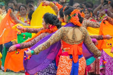 Kolkata, Hindistan - 1 Mart 2018: Renkli sari (geleneksel Hint elbisesi) ve Palash çiçekleri (Butea monosperma) giymiş kız dansçılar, Dol (Bengalce) veya Holi (Hintçe) festivalinde dans ediyorlar..